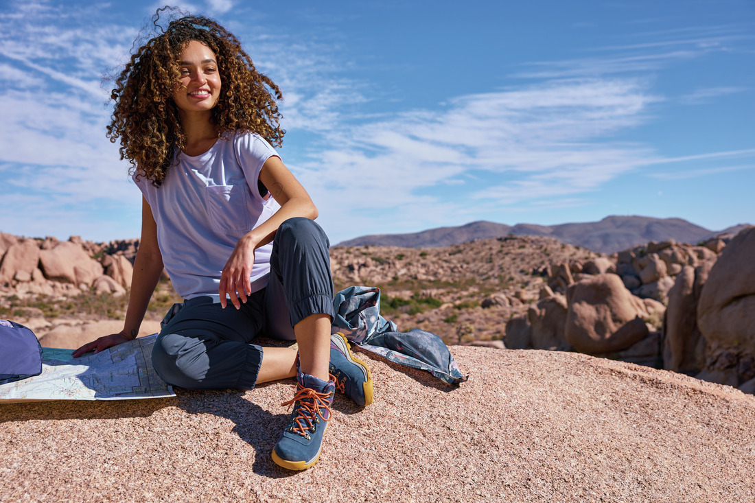 Mulher em ambiente de montanha usando bota de trilha feminina Columbia, representando as melhores botas femininas para trilha em 2025.