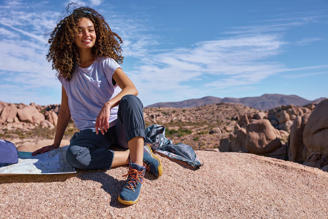 Mulher em ambiente de montanha usando bota de trilha feminina Columbia, representando as melhores botas femininas para trilha em 2025.