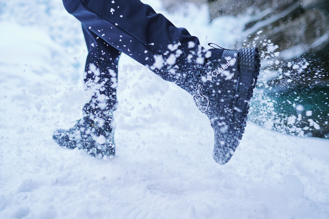 Pessoa correndo na neve com bota Columbia preta, representando a melhor bota para neve feminina com tração e proteção em ambientes gelados.
