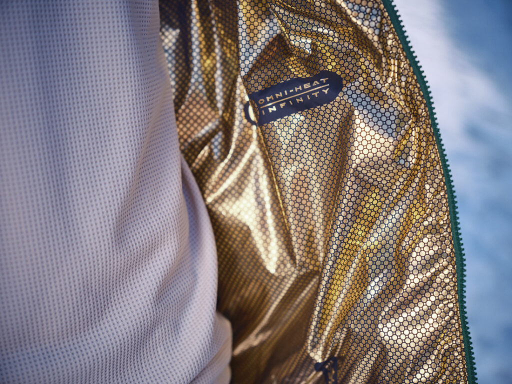 Detalhe do forro dourado Omni-Heat™ Infinity da jaqueta Columbia, tecnologia refletiva que conserva o calor corporal e melhora o isolamento térmico no frio.