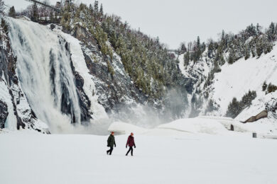 Casal explorando paisagem nevada com roupas Columbia, representando o guia completo sobre o que vestir na neve.