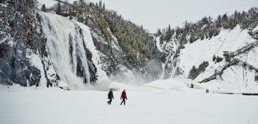 Casal explorando paisagem nevada com roupas Columbia, representando o guia completo sobre o que vestir na neve.