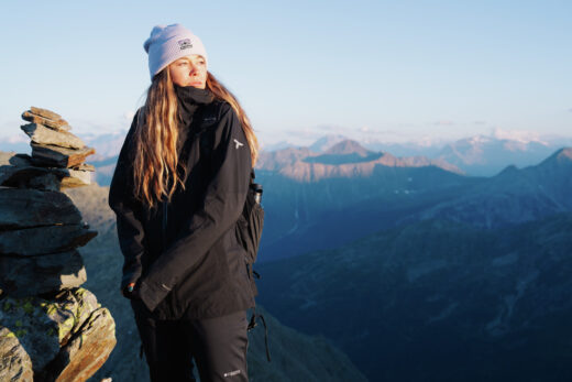 Pessoa usando roupa térmica Columbia preta em ambiente de montanha, demonstrando aquecimento e conforto em clima frio.