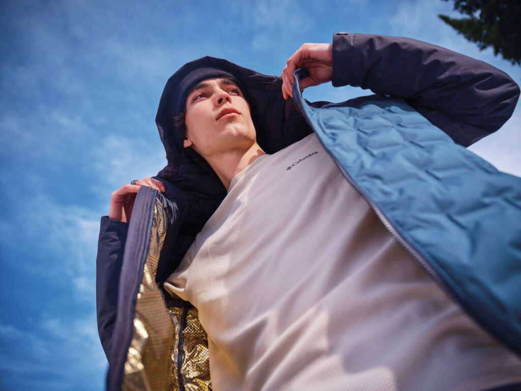 Pessoa usando jaqueta e blusa térmica Columbia com forro dourado Omni-Heat™ Infinity, simbolizando o conforto e a performance das roupas térmicas Columbia no frio intenso.