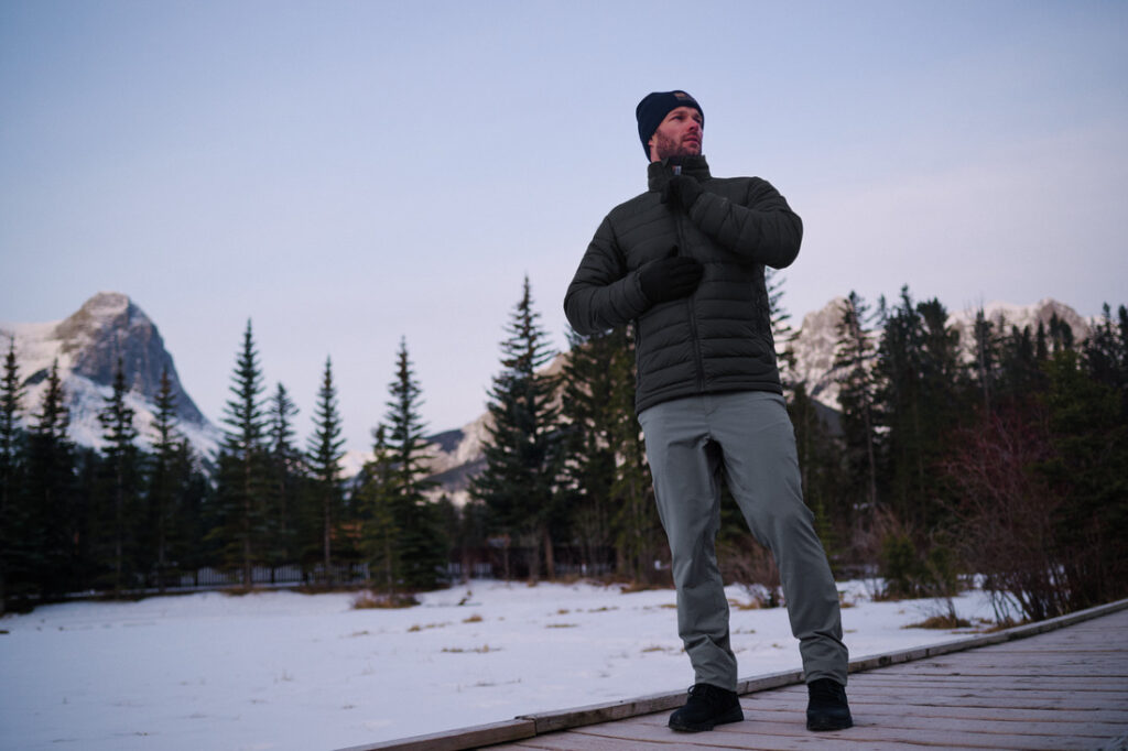 Homem usando jaqueta Columbia em ambiente de montanha com neve, representando como escolher as roupas certas para o frio intenso.